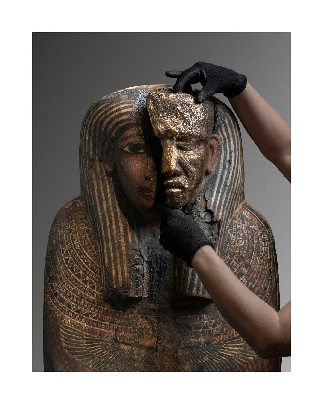 Polished bronze element held against an Egyptian statue from the Museo Egizio