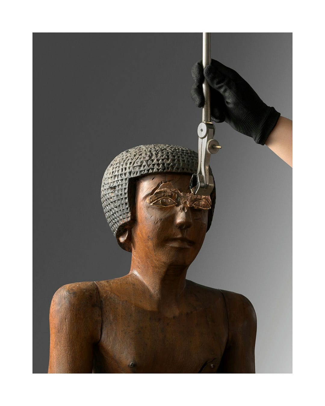 Fitting a bronze gaze onto a wooden statue from the collection