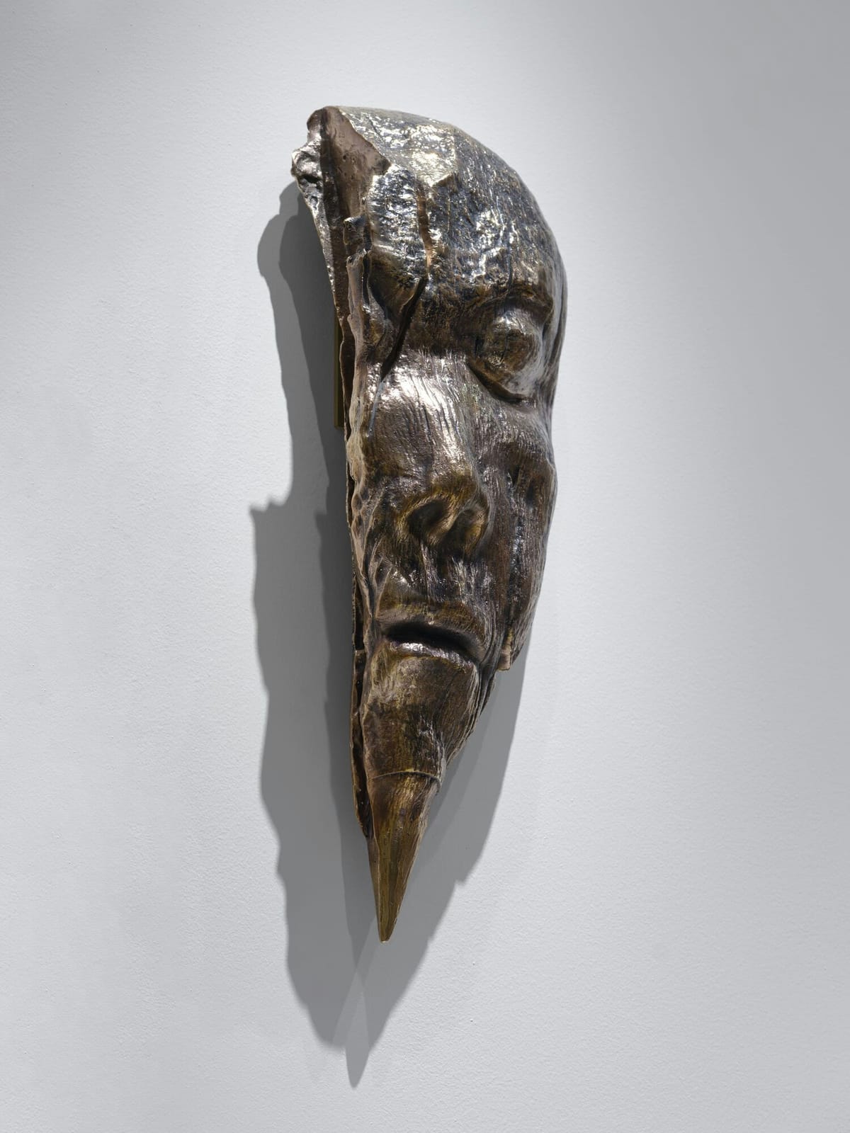 Fragment of a polished bronze face, seen from the front