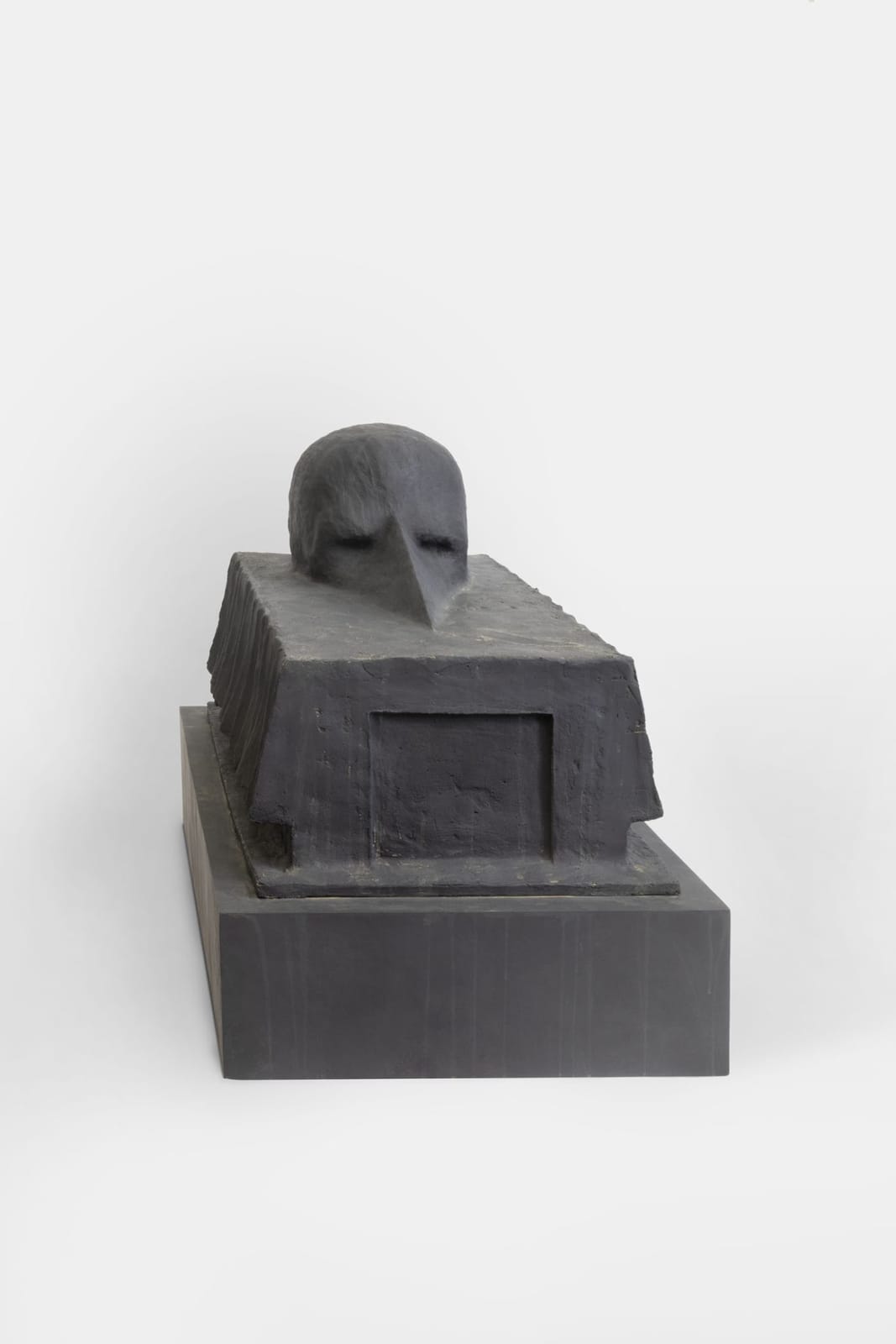 The same sculpture seen frontally on its stepped plinth, white studio background