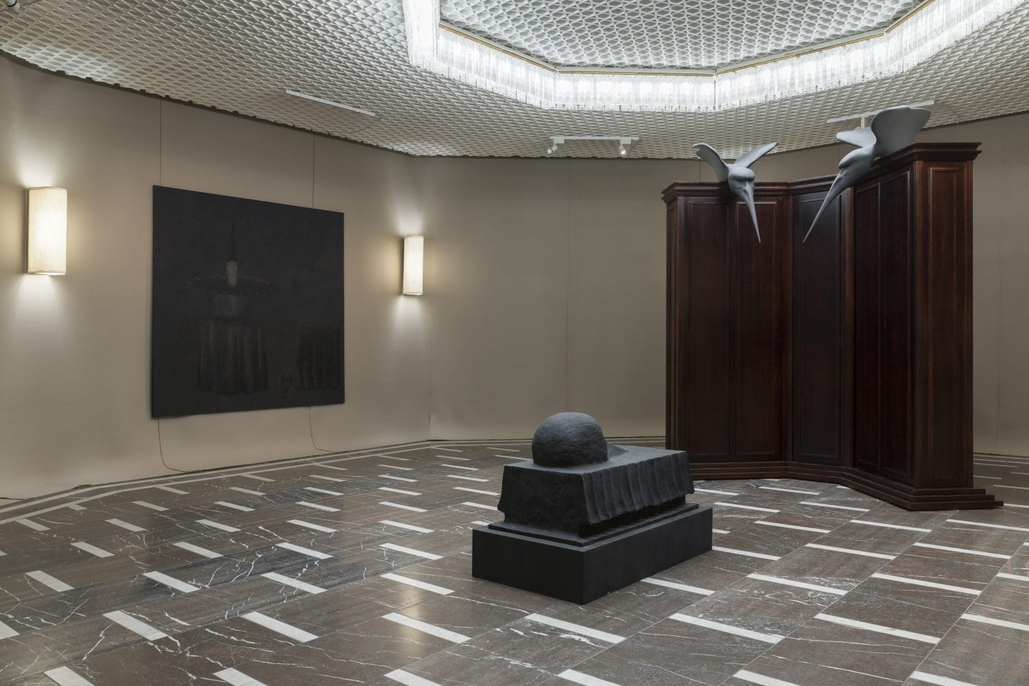 Room at the Schinkel Pavillon: dark painting, marble floor and panelling topped by two bronze birds